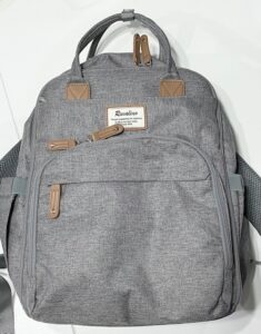 photo of the front of a grey backpack with tan leather zipper pulls